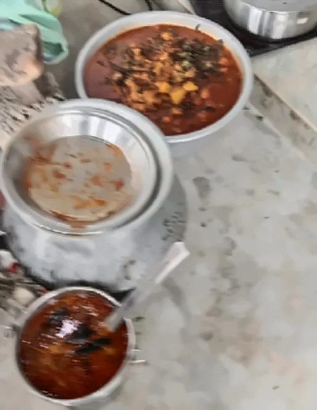 Steel vessels of curry and rice on a stone counter