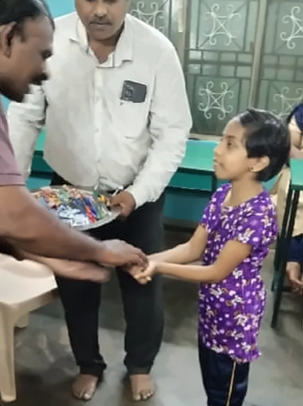 A man giving a girl in a purple dress a plate of stationery
